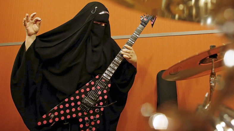 Gisele Marie, a Muslim woman and professional heavy metal musician, plays her Gibson Flying V electric guitar during a rehearsal at a studio in Sao Paulo January 27, 2015. Based in Sao Paulo, Marie, 42, is the granddaughter of German Catholics, and converted to Islam several months after her father passed away in 2009. Marie, who wears the Burka, has been fronting her brothers' heavy metal band "Spectrus" since 2012. "People do not expect to see a Muslim woman who uses a Burqa, practices the religion properly and is a professional guitarist who plays in a Heavy Metal band, so many people are shocked by it. But other people are curious and find it interesting, and others think that it is cool, but definitely, many people are shocked," said Marie. Picture taken January 27, 2015. REUTERS/Nacho Doce