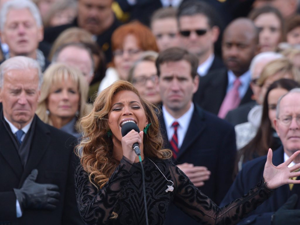 Beyonce performs the National Anthem as then-U.S. Sec. of State Hillary Clinton looks on in the background at the ceremonial swearing-in of President Obama in 2013
